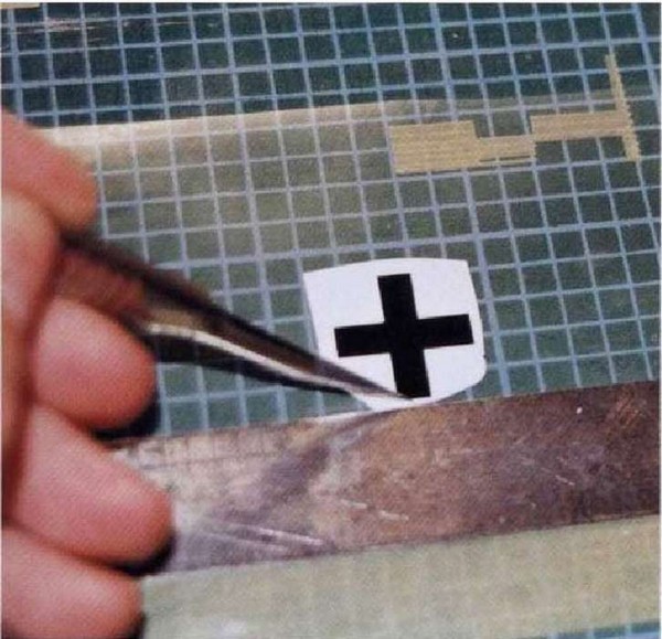 Положите прозрачную пленку поверх переводной картинки и, используя стальную линейку и скальпель, тщательно вырежьте крест.