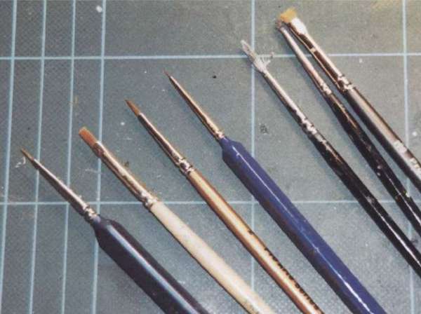 Выбор кисточек: кисть с синей ручкой в центре имеет только несколько щетинок и используются для заполнения расшивки, в то время как широкая кисть справа от нее -для метода 
